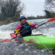 Person kayaking in a green kayak on a river with rapids in Dublin.